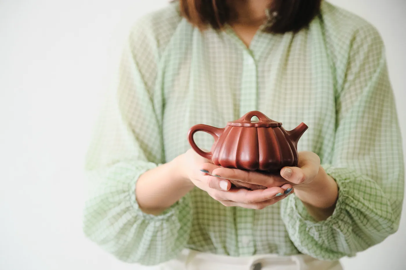 A Yixing teapot held in two hands